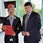 Wei Li mit Geschenk und Doktorhut neben sich Prof. Boccaccini