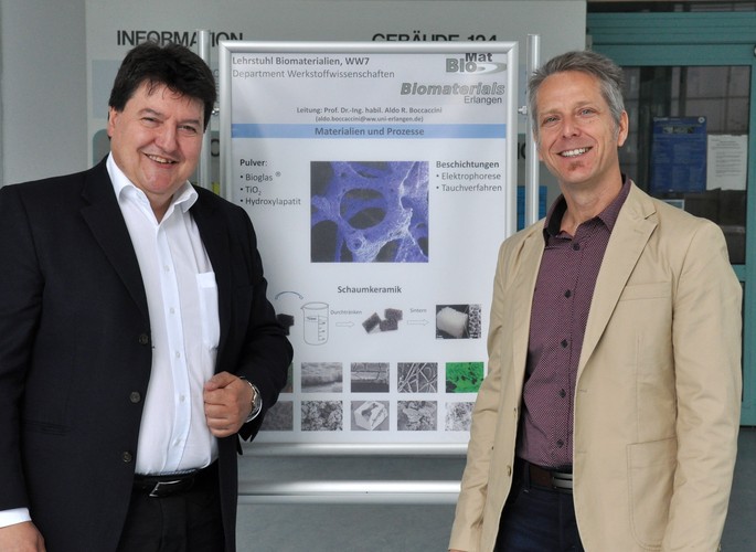 Professor Boccaccini together with Professor Pivonka infront of a poster about bioactive glass scaffolds.