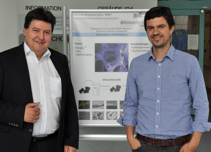 Professor Boccaccini zusammen mit Professor Jose Antonio Sanz-Herrera, vor einem Poster über bioaktive Gläser.