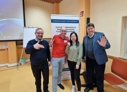 Prof. Boccaccini standing with institute members next to the meetings banner