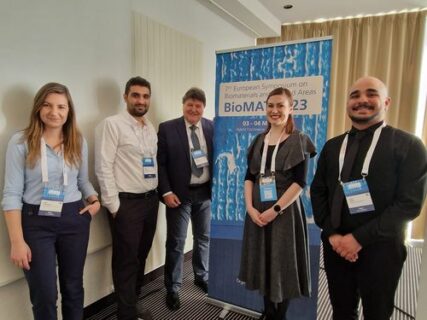 Prof. Boccaccini standing with Zoya, Qaisar, and collaborators from Slovakia, next to the conference banner.