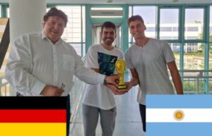 Prof. Boccaccini standing in the hall of the institute with the visiting students, holding the Football world cup