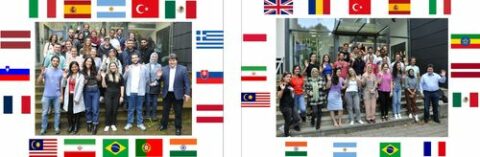 All of the Institutes visitors standing by the entrance, surrounded by their countries flags.