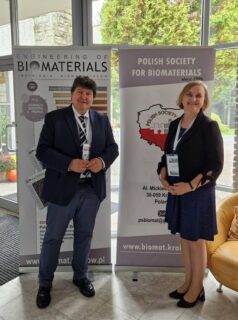 Prof. Boccaccini standing with Prof. Elżbieta Pamuła next to the conference banner