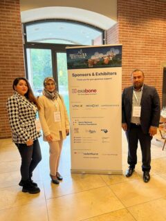 Dr. Nawaz, Dr. Poursharestani and Ms. Azari standing next to a conference banner.