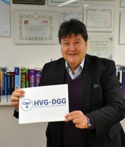 Prof. Boccaccini standing with a sign that reads "HVG-DGG"