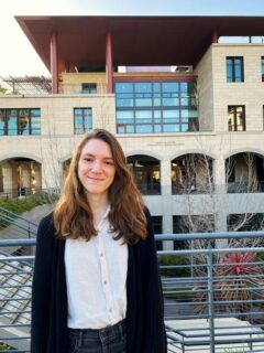 Ms Schoebel standing in front of a Stanford building