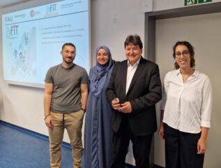 Prof. Boccaccini standing in front of the screen with the three speakers.