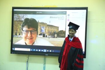 Prof. Boccaccini connected from a zoom meeting and Lulseged standing in academic robes on the right.
