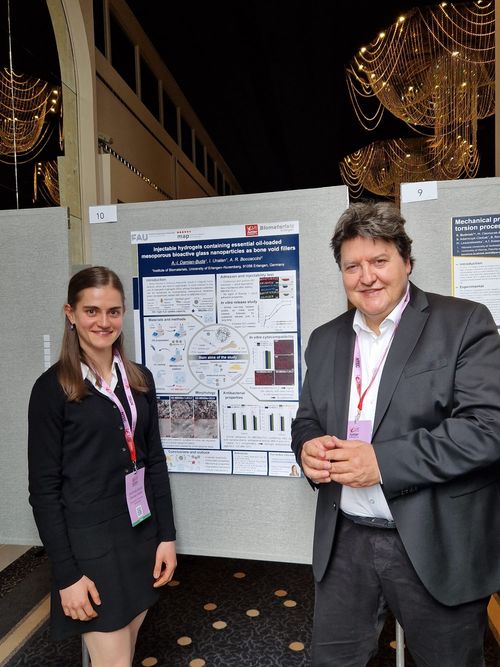 Prof. Boccaccini and Ms. Andrada, master student, smiling in front of the poster