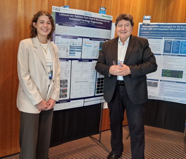 Ms Kissel and Prof. Boccaccini smiling in front of the poster