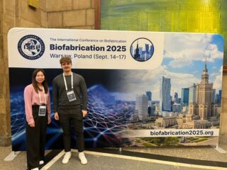 Markus and Hsuan-Heng smiling in front of the biofabrication poster